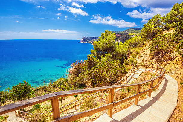 Walk to Cala Es Cubells in Ibiza Walk down to the beautiful beach of Cala des Cubells overlooking the coastline. balearic islands photos stock pictures, royalty-free photos & images