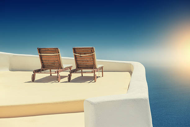 Empty Sun Lounge Chair on balcony In Santorini at Sunset