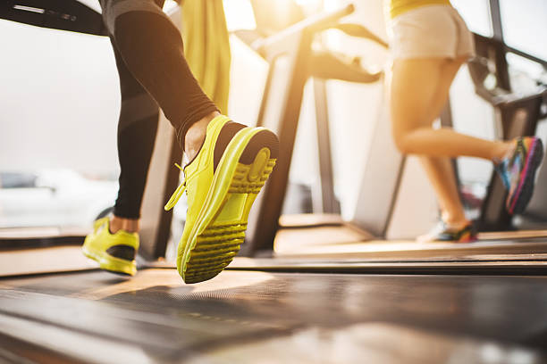 raffigurate persone non riconoscibili in esecuzione sul tapis roulant in palestra. - macchina per allenamento foto e immagini stock