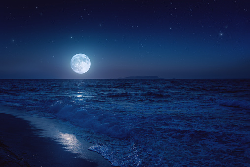 Rising moon over sea. Stock photo.