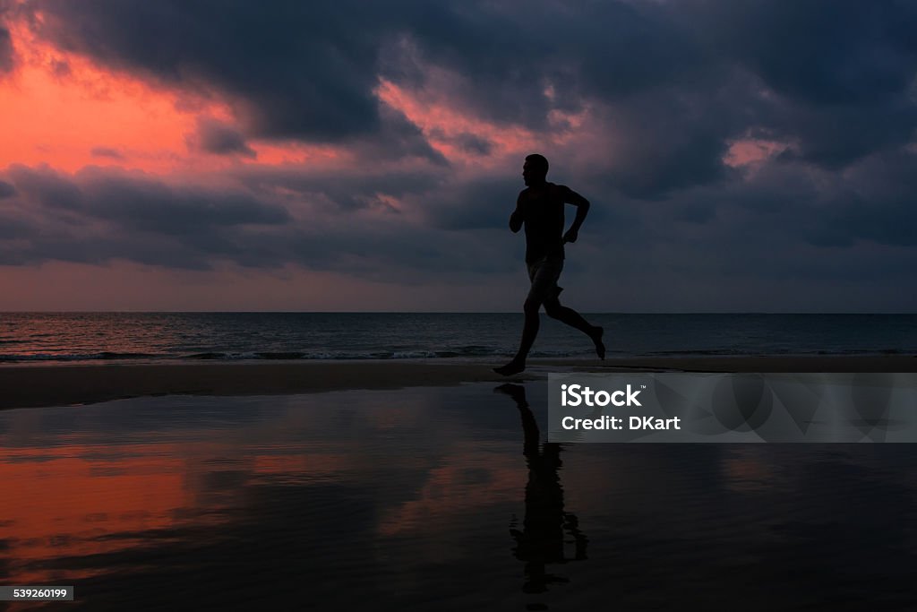 Running man Man running on the beach at sunset, Grain added 2015 Stock Photo