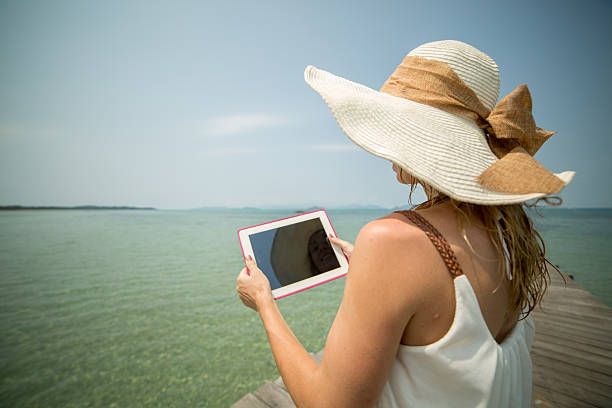 istock Woman on tropical Island using digital tablet 539260975