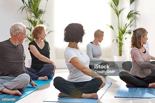 Group Of Mature People Practicing Yoga Stock Photo - Download Image Now - Back, Rear View, Stretching