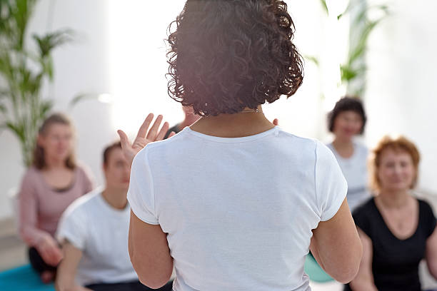 Female instructor guiding student during yoga class