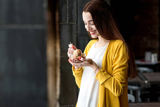 mujer comiendo un helado en la cafetería - women spoon tasting elegance fotografías e imágenes de stock