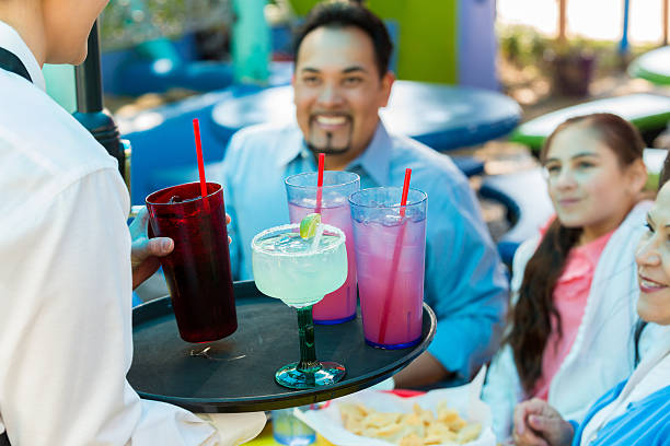 istock Waitress serving drinks to diners on patio at restaurant 539270045