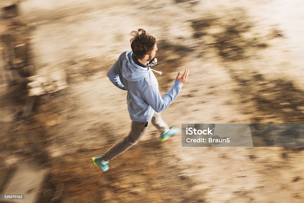 High angle view of a man running in blurred motion. Above view of a young man jogging. Blurred motion. Active Lifestyle Stock Photo