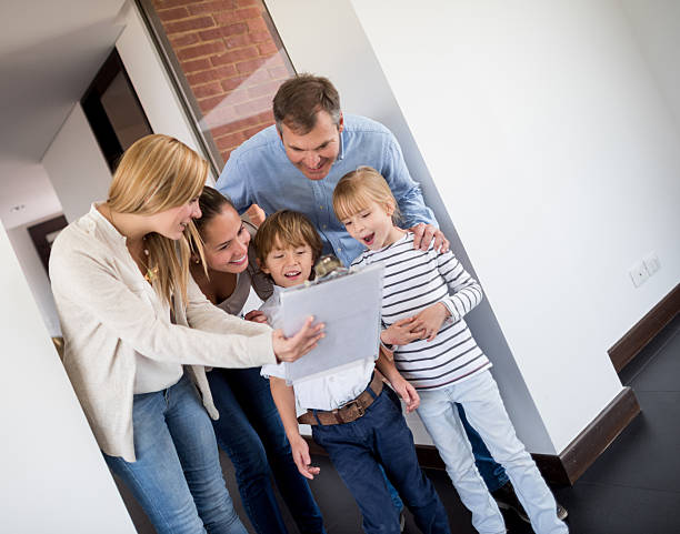 agente immobiliare mostrando una famiglia a casa - clipboard men sales occupation casual foto e immagini stock