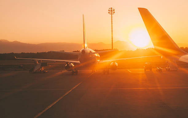 Sunset at the airport Airplane, jumbojet on runway preparing for takeoff at sunset at the airport warm sunset stock pictures, royalty-free photos & images