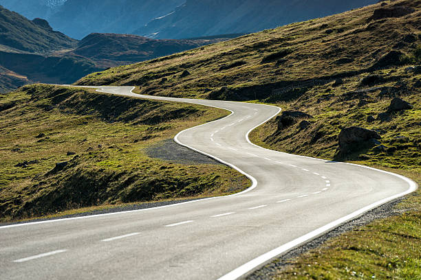 DSLR photo of a landscape with a winding mountain road with many curves in the austrian alps leading from Galtuer in Tyrol above the Silvretta Bielerhoehe to Vorarlberg. Nobody is on the street at this sunny day.