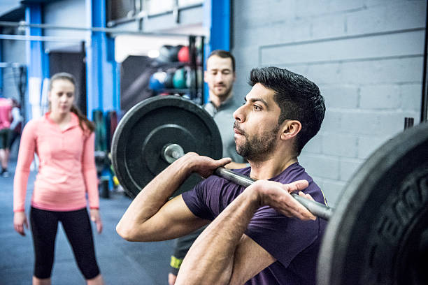 istock Man lifting barbell weights in gym 539271961
