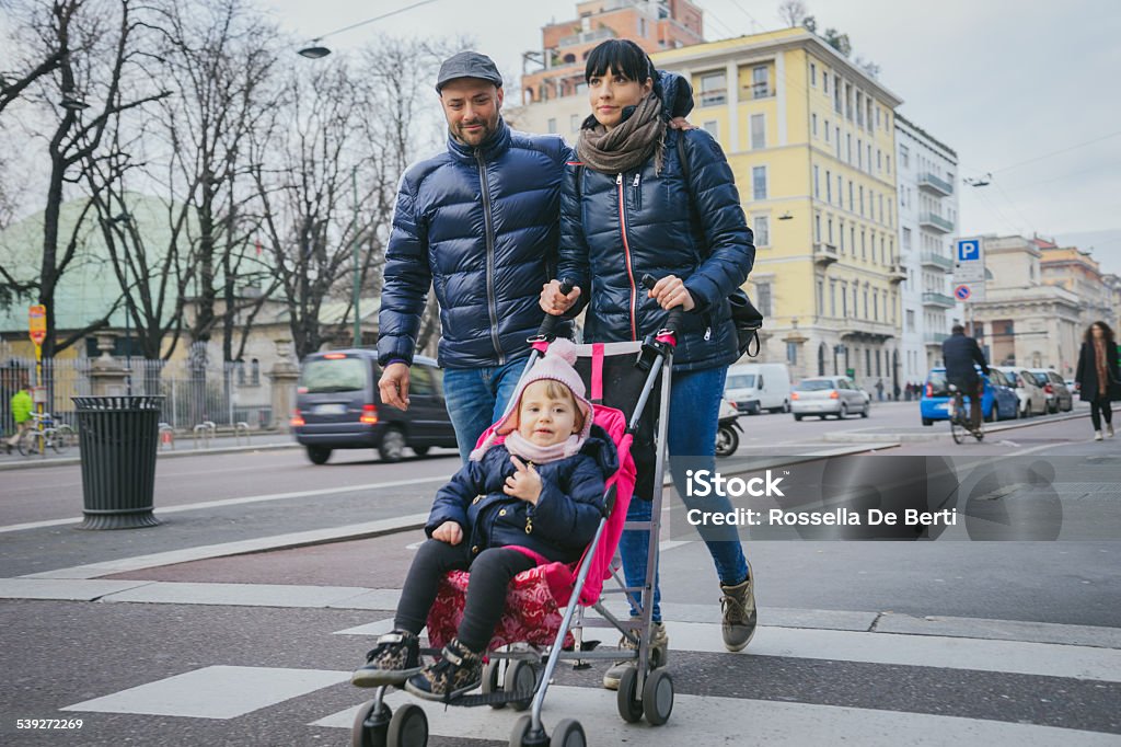 Happy Family Crossing The Street Happy family crossing the street. Baby Stroller Stock Photo