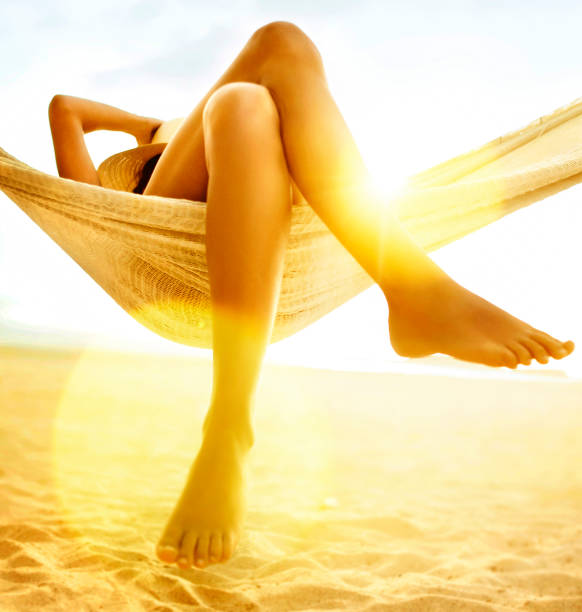 Woman relaxing in hammock on beach