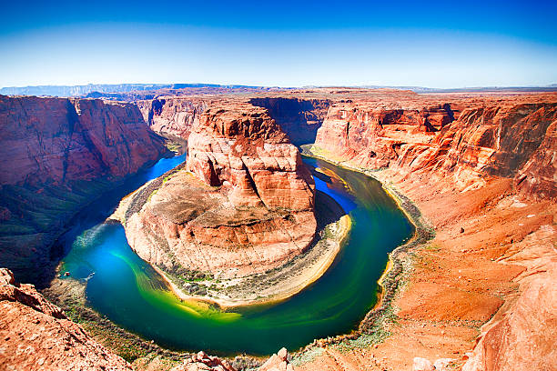 Horseshoe Bend Colorado River Horseshoe Bend at the Colorado River in hues of bright orange, greens, blues and yellows. This natural attraction is located in Page Arizona. Taken with a 5D mark 3 Camera. grand canyon of yellowstone river stock pictures, royalty-free photos & images