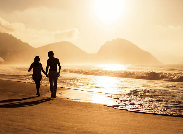 istock Couple walking on the beach at sunset. 539281787