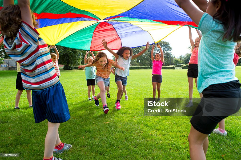 Outdoor Games Children playing a game with a colourful Parachute Child Stock Photo