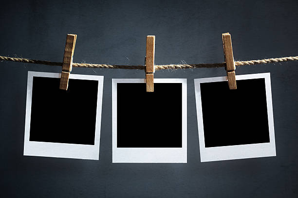Blank polaroid photographs hanging on a clothesline Blank instant print transfer polaroid photographs hanging on a clothesline string photos stock pictures, royalty-free photos & images