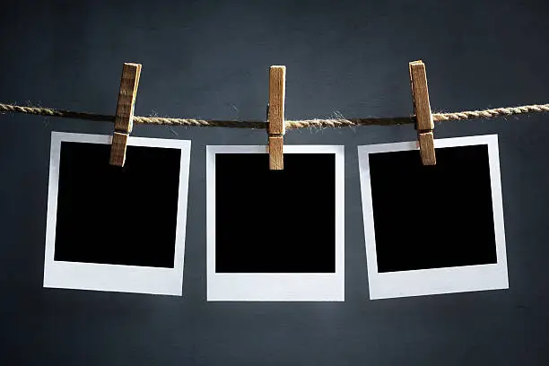 Blank instant print transfer polaroid photographs hanging on a clothesline