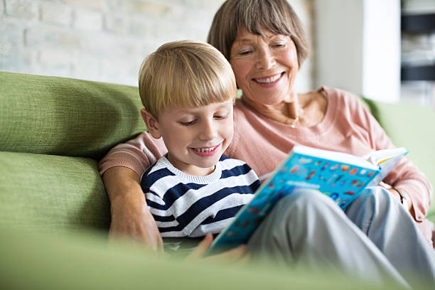 rapaz com a sua avó, ler um livro - grandparent reading grandmother child imagens e fotografias de stock