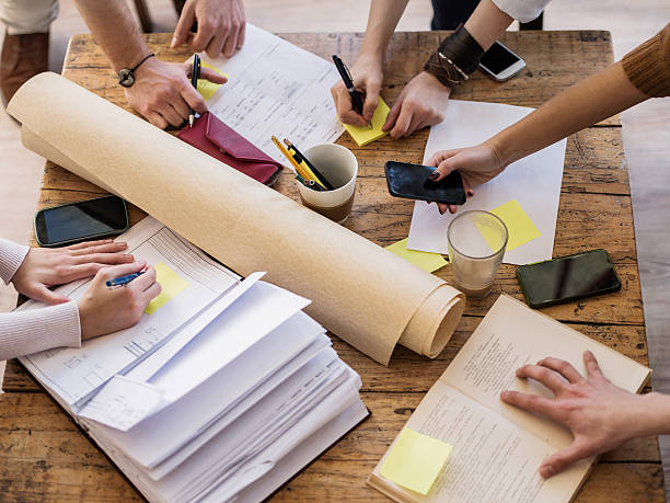 Above view of unrecognizable multi-tasking creative people.