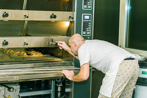 istock Baker check cooking breads in to oven 539292577