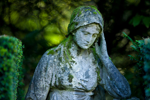Old weathered  bust of a young woman at the Melaten Graveyard in Cologne, Germany