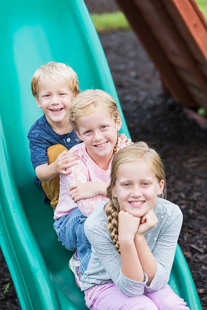 istock Little boy and two girls on playground slide 539294837