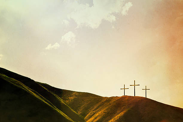 Crosses on Hillside A depiction of the crucifixion of Jesus Christ, three crosses on a hill. Imagery intended to represent the crucifixion and resurrection of Jesus Christ celebrated on Easter sunday. Horizontal image with copy space. religion stock pictures, royalty-free photos & images