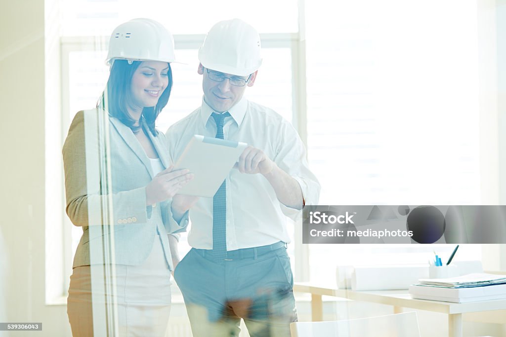 Construction industry Two business people looking at digital tablet and businessman pointing at screen 2015 Stock Photo