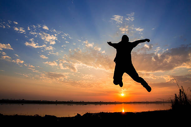 istock Silhouette of a man jumping over sunset background 539306393