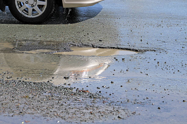 istock Motorist Avoiding A Water Filled Pothole On A City Street 539306803