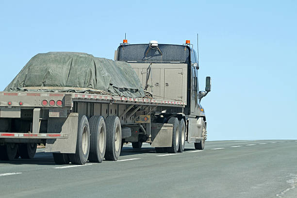 istock Semi Flatbed Trailer Truck With Covered Load On A Highway 539307331