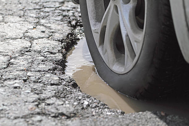 istock Alloy Wheel And Tire In A Pothole, Closeup 539307771