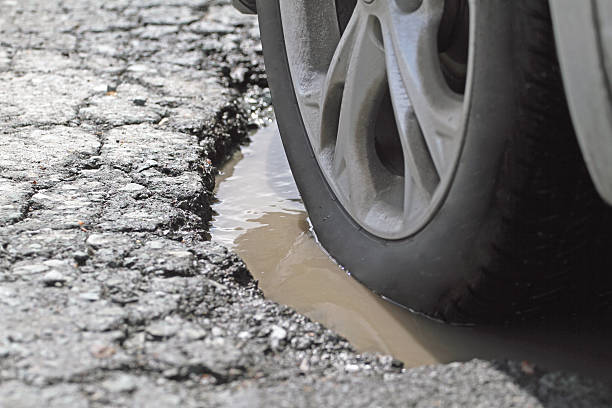 Alloy Wheel And Tire In A Pothole, Closeup stock photo