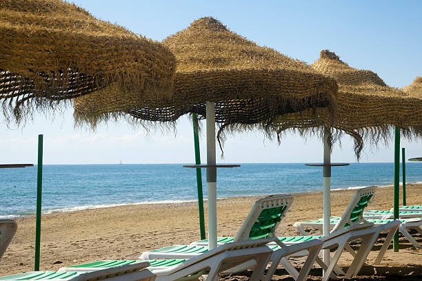 Torremolinos beach, Malaga, Costa del Sol, Spain. Torremolinos beach with sun umbrellas and deck chairs in Málaga, Costa del sol, Spain.  torremolinos beach stock pictures, royalty-free photos & images