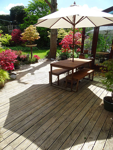 istock Image of garden timber-decking, table and benches with parasol umbrella 539309131