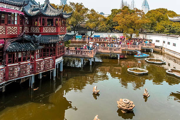 Tourists walking on Nine Zigzag Bridge in Yuyuan, Shanghai, China. Yuyuan is one of the busiest commercial districts in Shanghai. Many buildings in Yuyuan area were first built during Ming Dynasty.