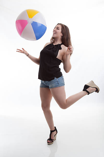 Summer Fashion Model Catches Beach Ball in Cute Outfit stock photo