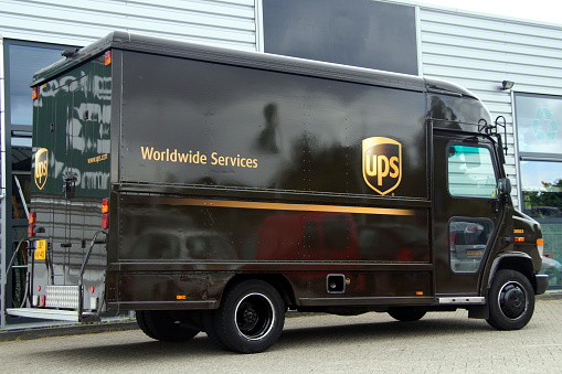 Almere Stad, Flevoland, The Netherlands - June 18, 2015: UPS delivery Truck parked by the side of the road in front of a office building. No people inside the vihicle. United Parcel Service, Inc. (UPS) is the world’s largest package delivery company.