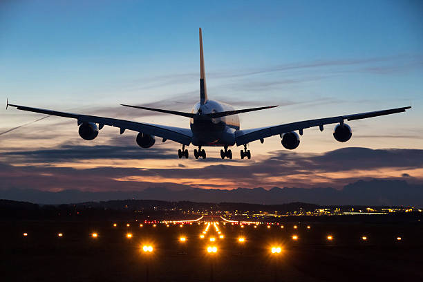 Landing airplane Photo of an airplane just before landing in the early morning. Runway lights can be seen in the foreground. airplane landing stock pictures, royalty-free photos & images
