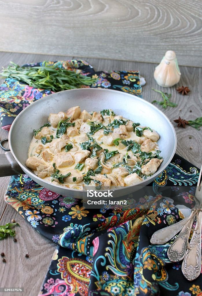 chicken in a creamy sauce with spinach and tarragon Crockery Stock Photo