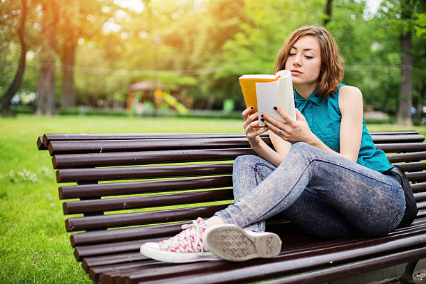 Free Stock Photo of Young woman on a bench reading book in the park ...