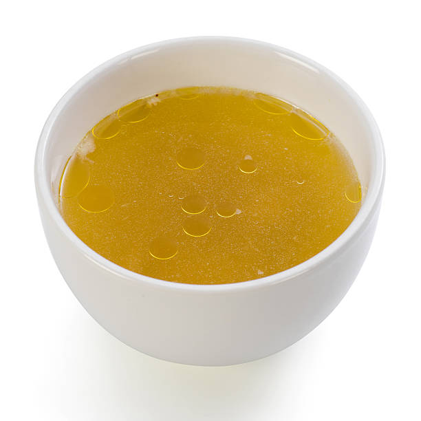 Bowl of clear chicken broth stock photo
