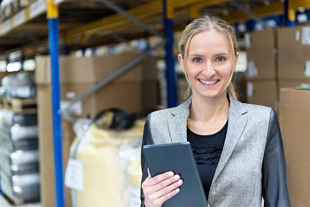 istock Cheerful young woman in warehouse holding tablet 539331218