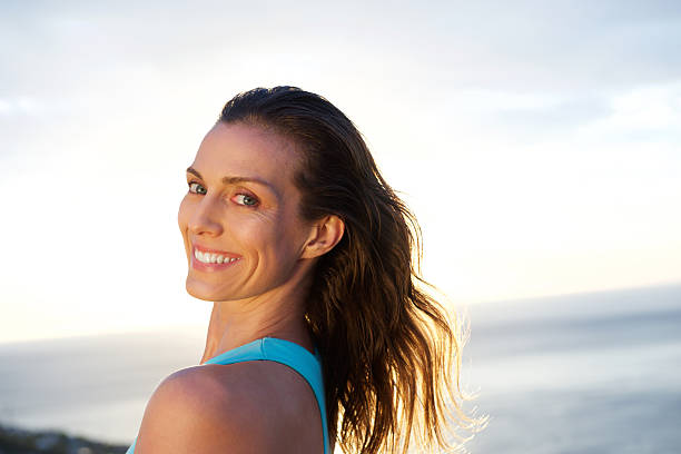 istock Woman looking over shoulder with sea in background 539332180