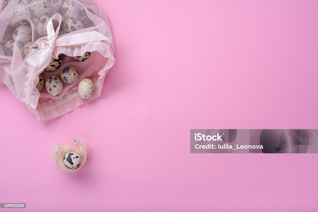 Quail eggs in pink bag New born child, baby shower or pregnancy greeting card concept. A bag full of quail eggs, egg in a birds nest over pink background. Affectionate Stock Photo