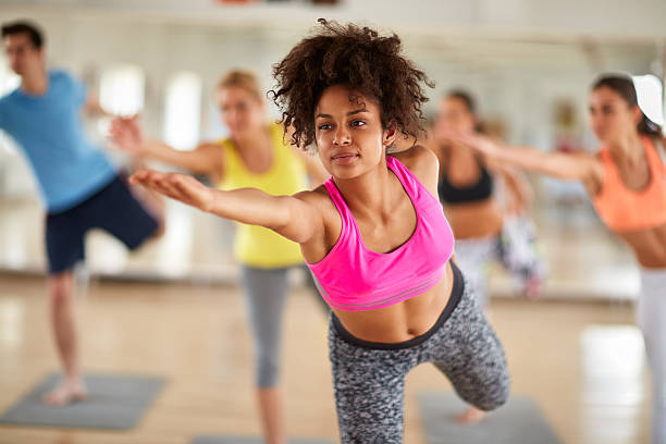 Close up of young woman on stretching training indoor Close up of attractive black curly woman on stretching training indoor aerobics stock pictures, royalty-free photos & images