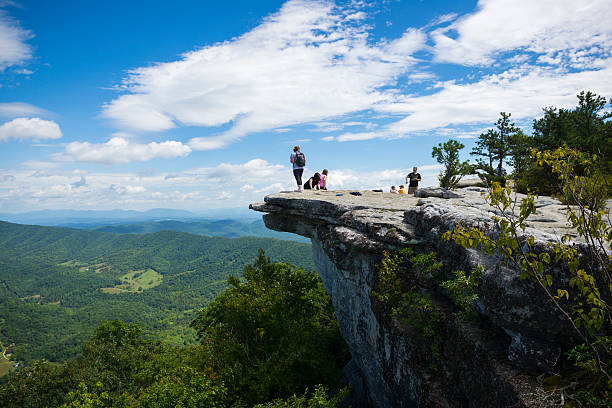 Hikers at McAfee Knob on Appalachian Trail in Virginia Catawba, Virginia, USA - September 1, 2014: Hikers enjoy the view of the Appalachian Mountains from McAfee Knob on Catawba Mountain, near Roanoke, Virginia. It is one of the most popular overlooks on the Appalachian Trail and is situated at an elevation is 3,171 feet. appalachian trail photos stock pictures, royalty-free photos & images