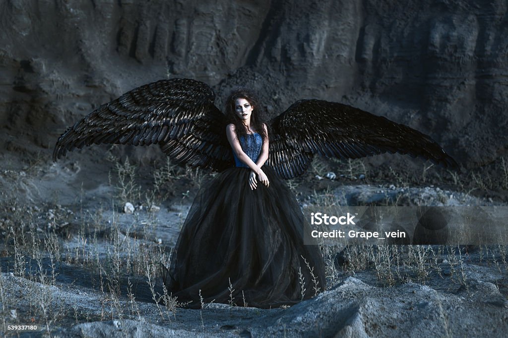 Angel with black wings Pretty girl-demon with black wings behind her back Women Stock Photo