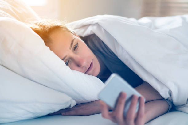 istock Blonde woman using phone in bed 539340356
